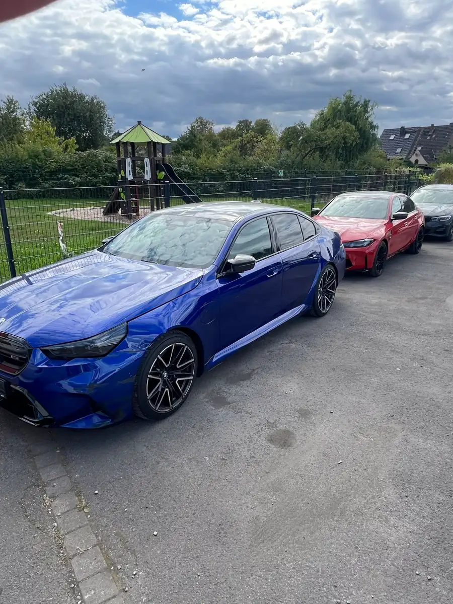 Blauer BMW auf dem Hof vor der Werkstatt