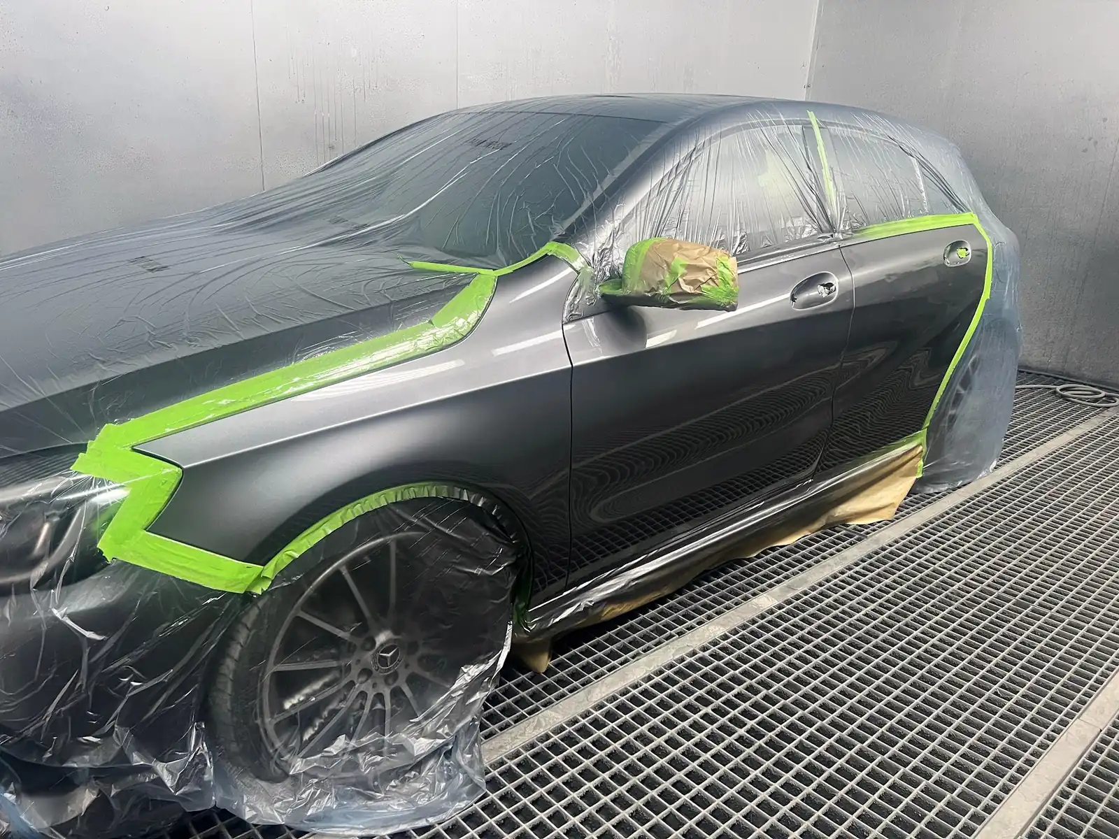 Mercedes in der Lackierkabine, sauber abgeklebt