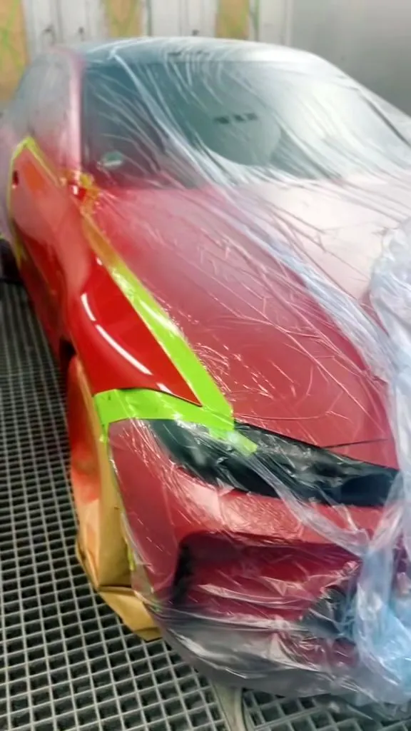 Rotes Fahrzeug in Folie, Front frisch lackiert