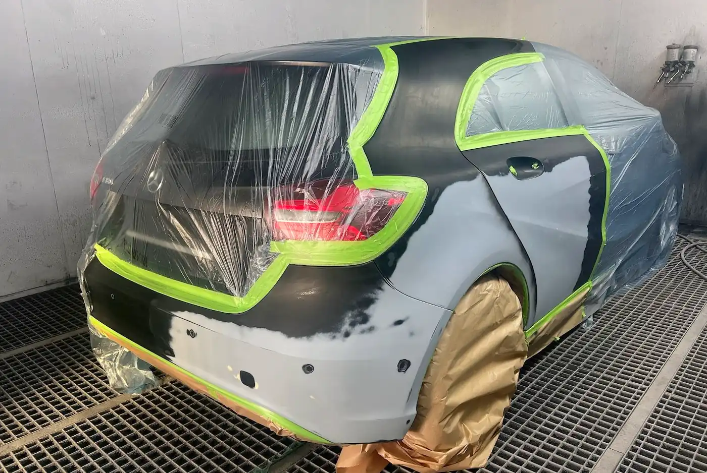 Mercedes A-Klasse in der Lackierkabine, abgeklebt, Seite und Heck grundiert